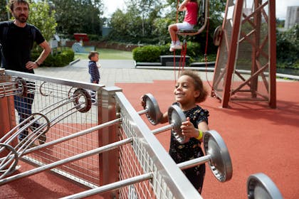 A young smiling girl plays in the ThinkTank Science Garden