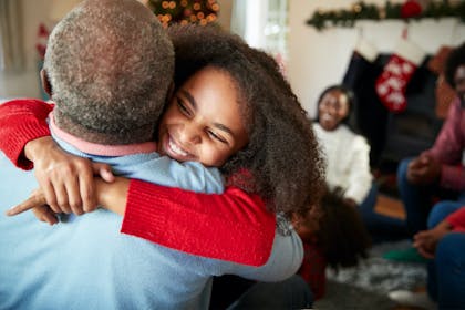 Granddaughter hugging grandfather at Christmas time