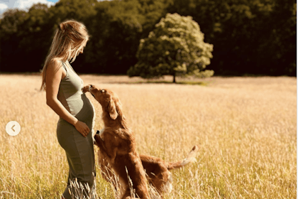 Pregnant woman in field with dog
