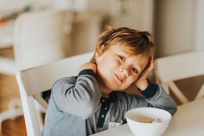 Child eating breakfast in pyjamas