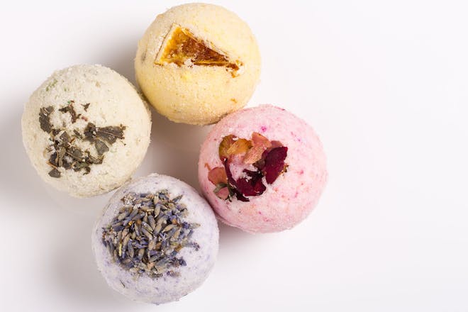 group of four homemade bath bombs decorated with dried flowers and fruit