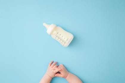 baby hands crawling towards baby bottle