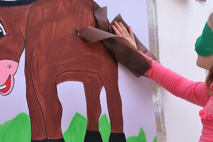 child playing pin the tail on the donkey