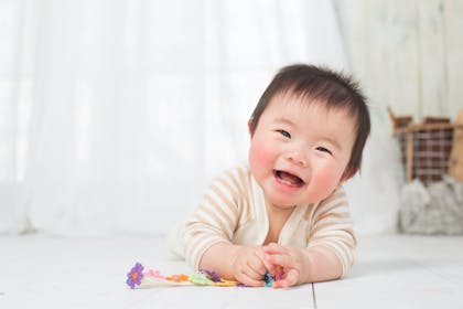 Baby laughing and playing with a toy