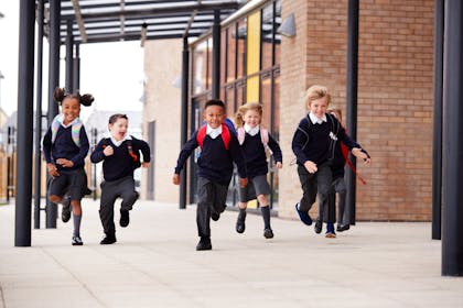 group of children running outside school 