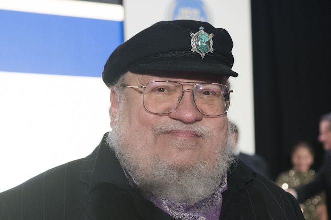 George R. R. Martin wearing cap with brooch on