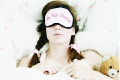 woman in bed sleeping with eye mask on