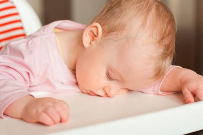 Baby asleep in highchair during weaning