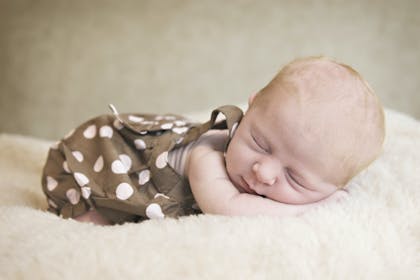 Baby sleeping in polka dot dress 