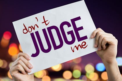 Hands holding up a 'don't judge me' sign