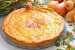cheese flan on a plate with a golden top to illustrate a recipe like the classic school dinners cheese pie