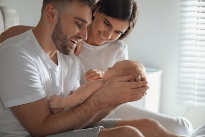 New parents cradle their small baby