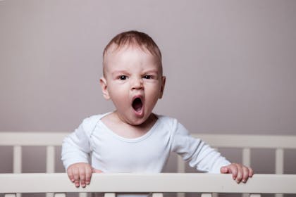 yawning baby in cot