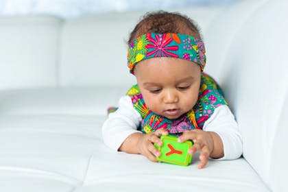 Baby girl playing with learning block