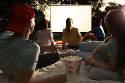 teenagers watching a film in the garden