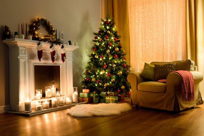 Cosy living room decorated with candles, stockings and Christmas tree