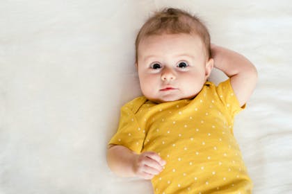 baby lying down wearing yellow
