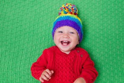 baby wearing colourful knitted hat