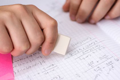 Child rubbing out sums with an eraser