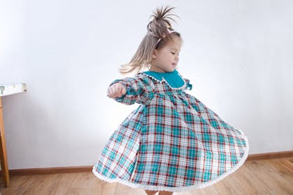 Toddler dancing at St Patrick's Day in tartan party dress