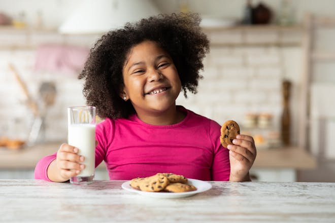child with milk and cookies