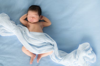 Baby lying on blue bed