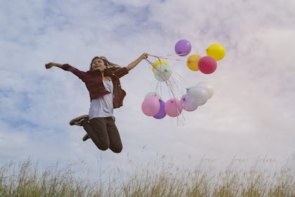 woman jumping with balloons