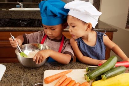 children in the kitchen wearing chef hats and cooking