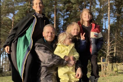 Charley Webb and Matthew Wolfenden pose outdoors with their three children 