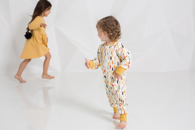 Two children running in white room