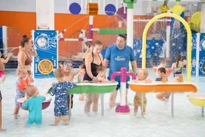 Families with young kids enjoy water activity tables at Brean Splash, Somerset