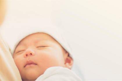 Newborn baby sleeping with hat on 