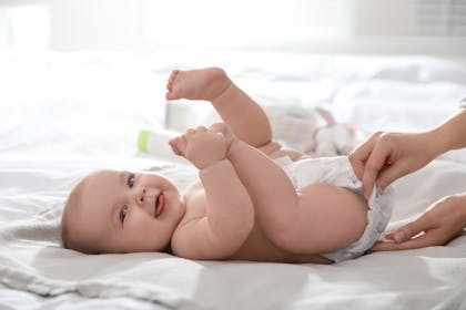 Smiling baby having nappy changed