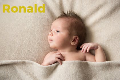 Baby lying in beige towel. Name Ronald written in text