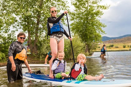 Mum and two children on stand up paddle board