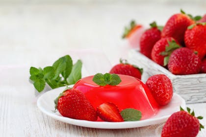 Summer dessert with red fruit jelly and fresh strawberries