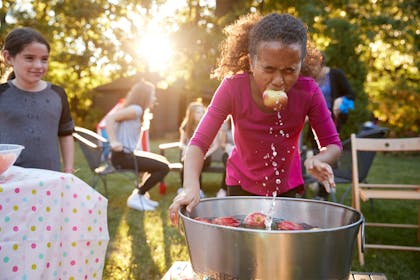 Little girl apple bobbing at a Halloween kids party