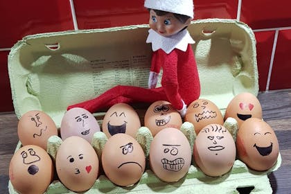Elf on the Shelf drawing faces on eggs