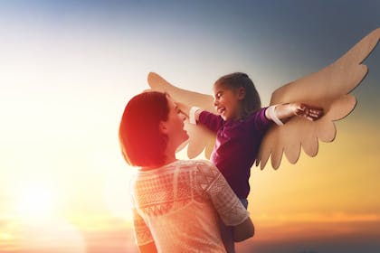Mum holding up daughter with wings