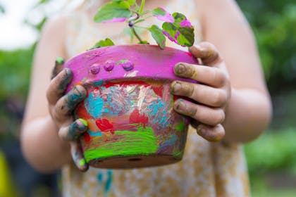 Child holding a hand-painted flower pot