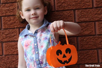 Girl holding a paper pumpkin basket