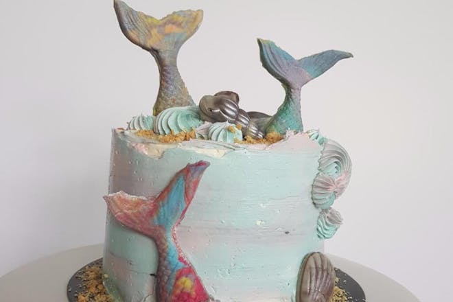 Blue marble birthday cake with sugar topper mermaid tails and shell decorations