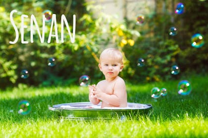 Baby on blanket in field with Irish name Senan