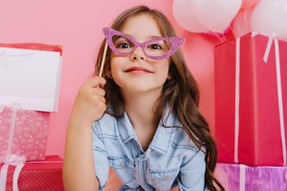 Young girl taking photo with glittery glasses on