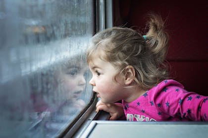 Little girl looking out of train window