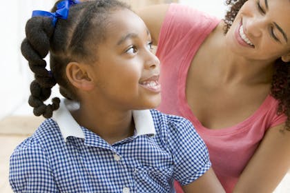 Girl in school uniform and mum smiling at each other