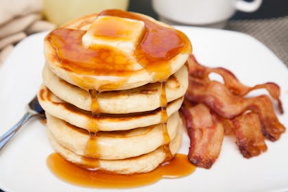Pancakes with bacon rashers and maple syrup