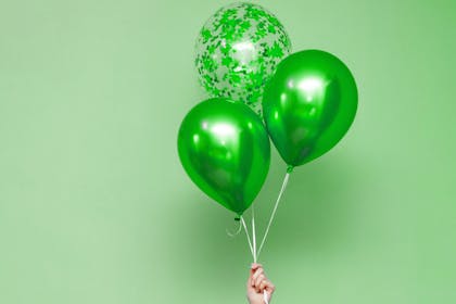 Hand holding green balloons