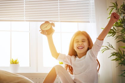 Excited child holding clock
