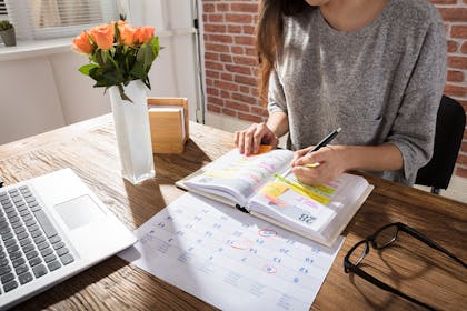 Woman writing in diary on desk